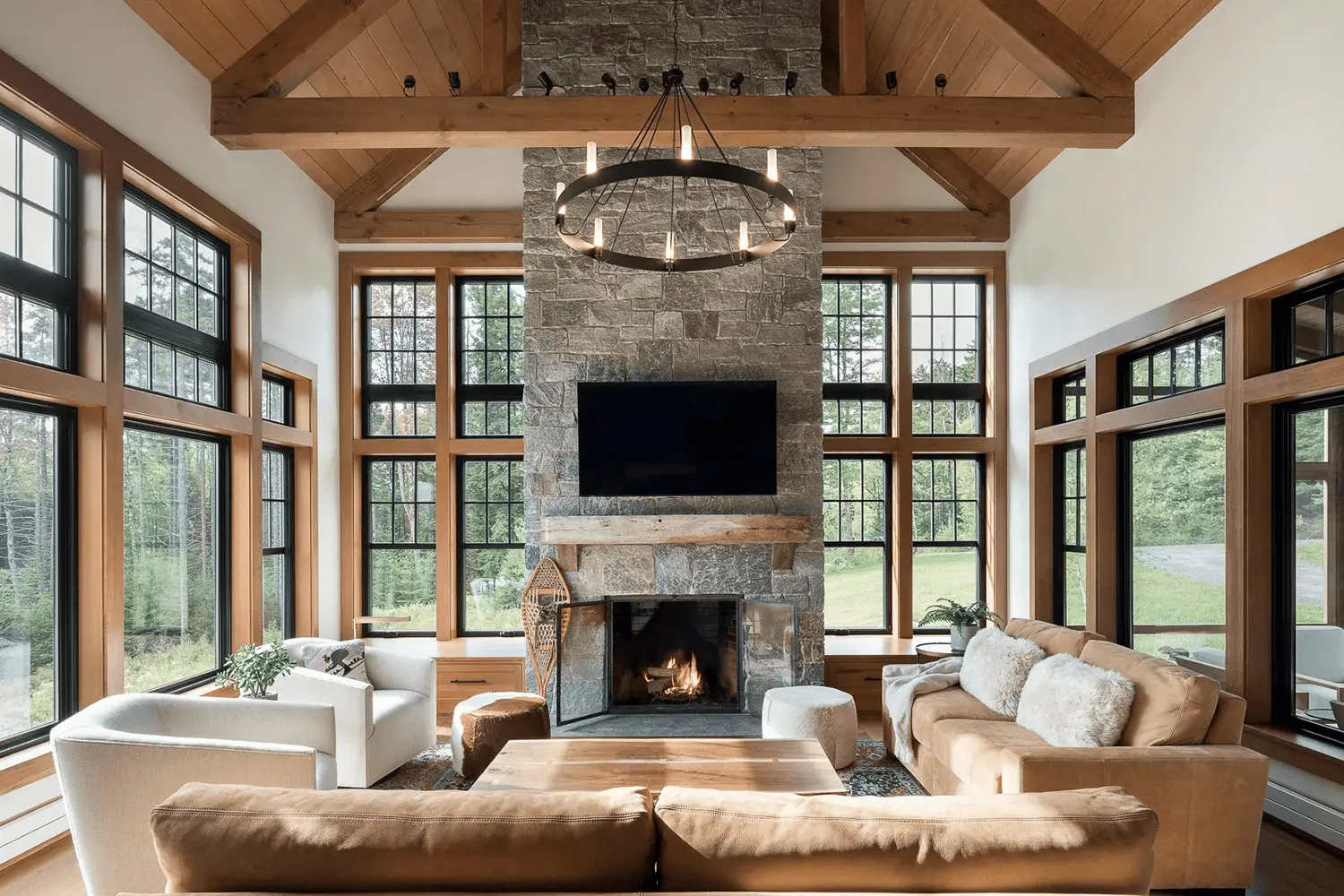 Phòng khách Rustic với ánh sáng tự nhiên tràn ngập và đèn thả trần bằng sắt rèn tạo điểm nhấn.